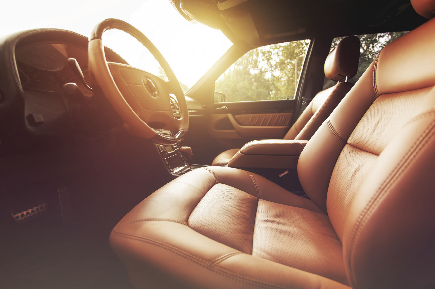 Premium car interior, brown leather at sunset